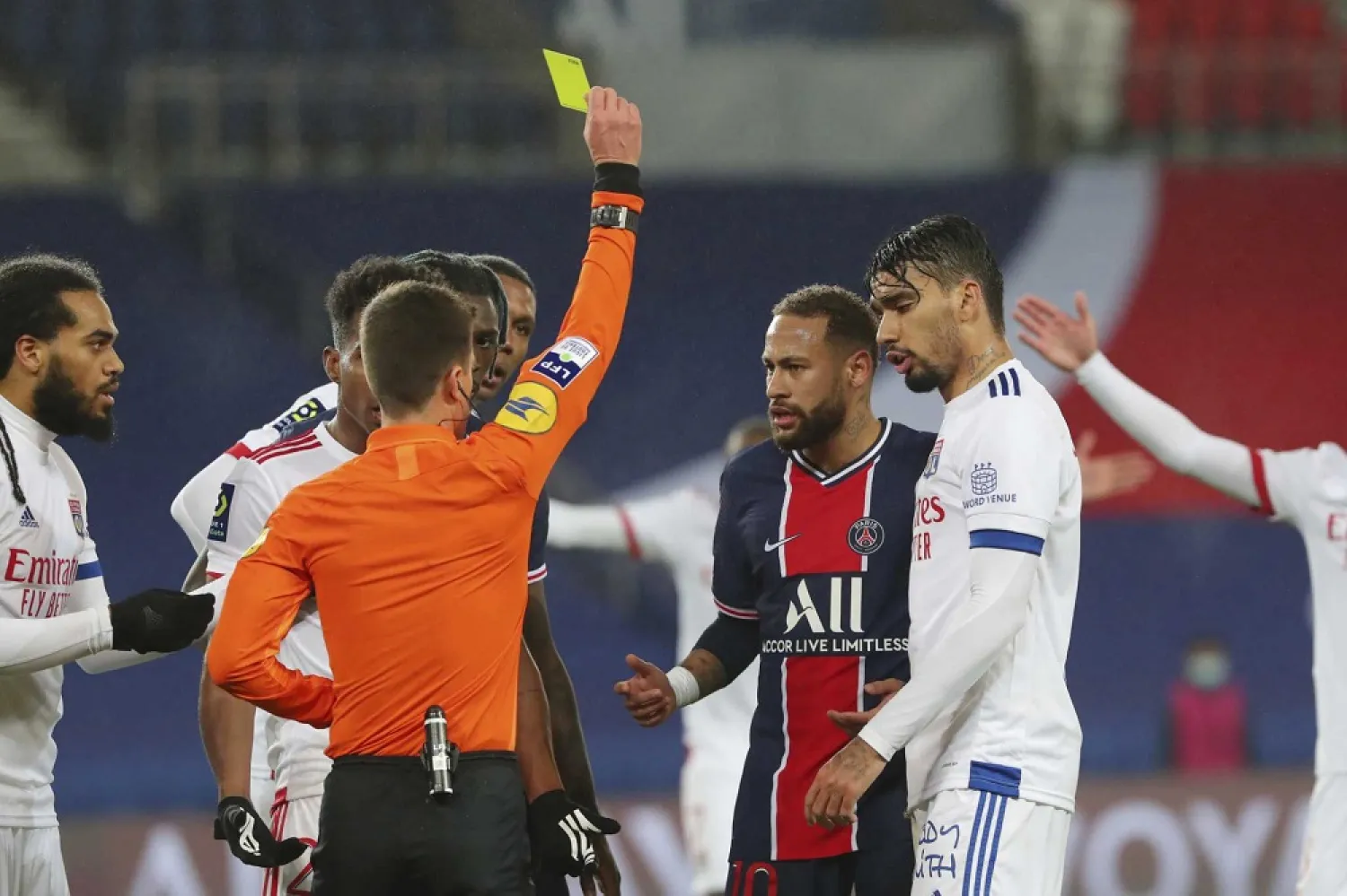 Referee Benoit Bastien shows a yellow card to PSG's Neymar, center, during the League One match between PSG and Lyon, at the Parc des Princes stadium in Paris, France, Dec. 13, 2020. (AP)