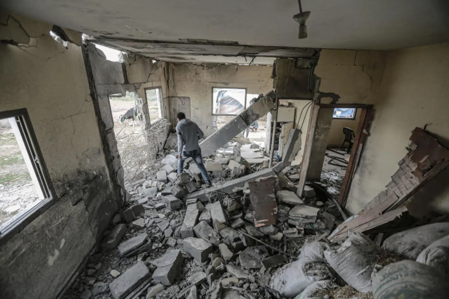 رجل يتفقد منزلاً مدمراً في غزة استهدفته قذيفة مدفعية إسرائيلية (د.ب.أ)