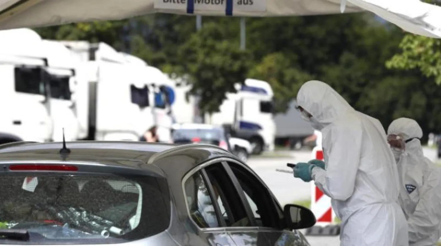 أحد العاملين في القطاع الطبي الألماني يسحب عينة لاختبار فيروس كورونا (أ.ب)