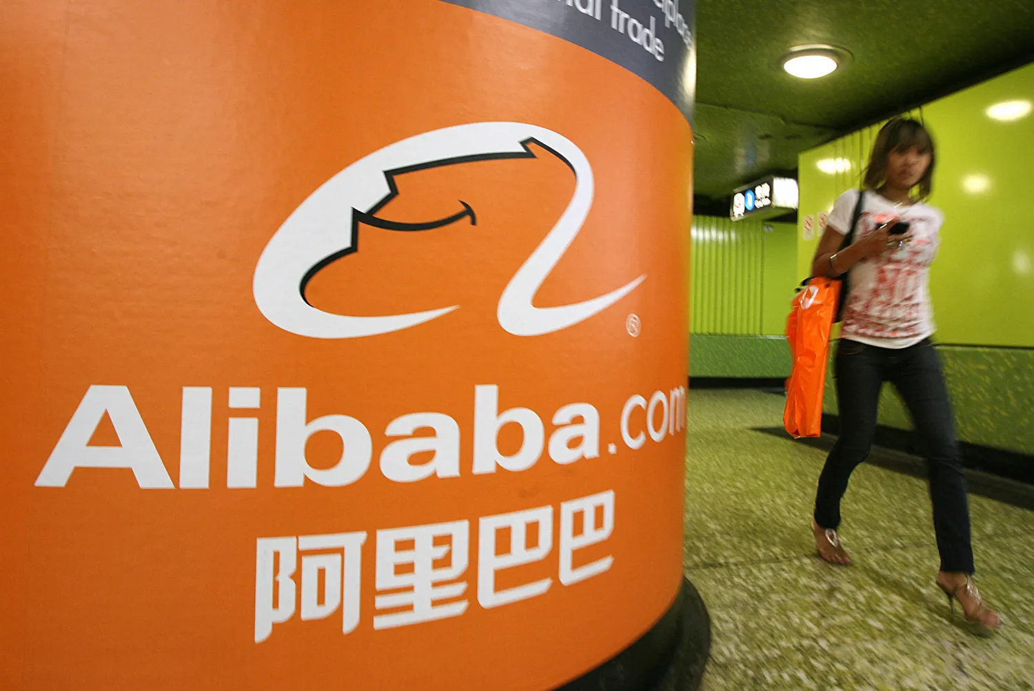 A pedestrian walks past Alibaba.com advertising in Hong Kong. MIKE CLARKE/ AFP
