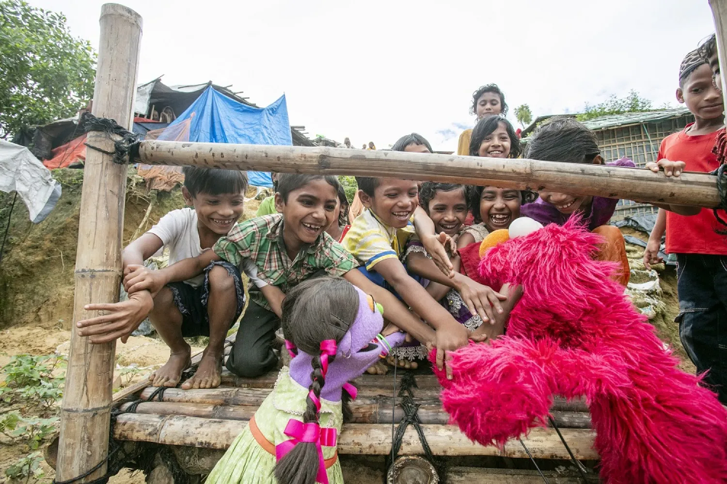 Elmo and Tuktuki play with a group of Rohingya refugee children in the Kutapalong camp in Cox's Bazar, Bangladesh. (Sesame Workshop)
