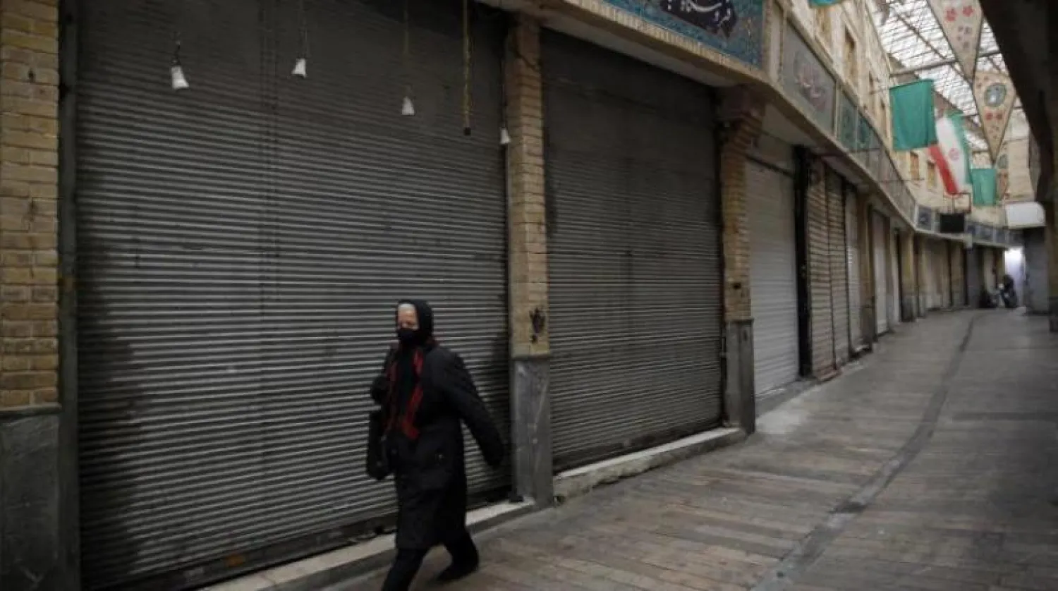 سيدة تضع كمامة في أحد شوارع طهران (إ.ب.أ)