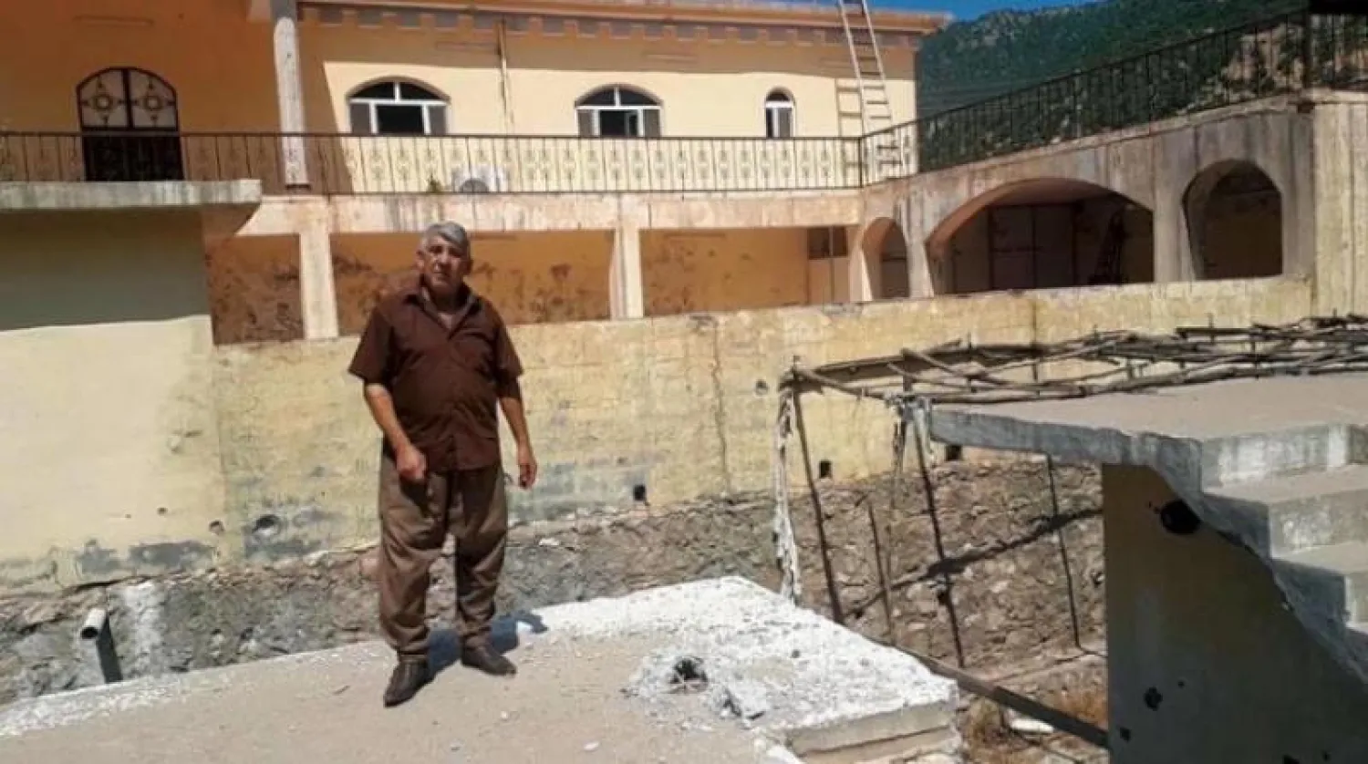 كردي يقف قرب فتحة أحدثها قصف تركي سابق في سقف منزله (الشرق الأوسط)