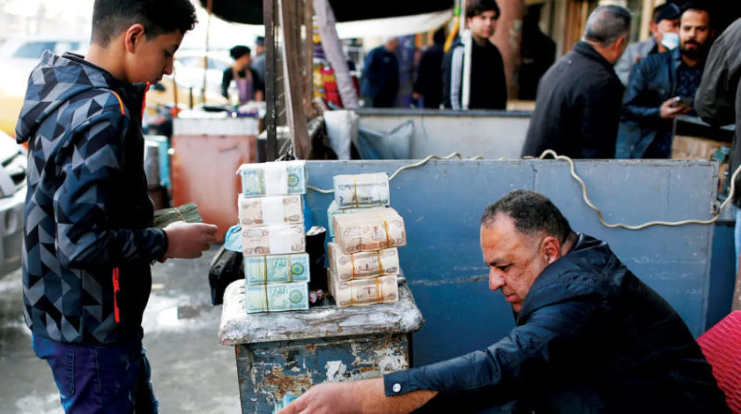 صراف في سوق العملات ببغداد أمس (رويترز)