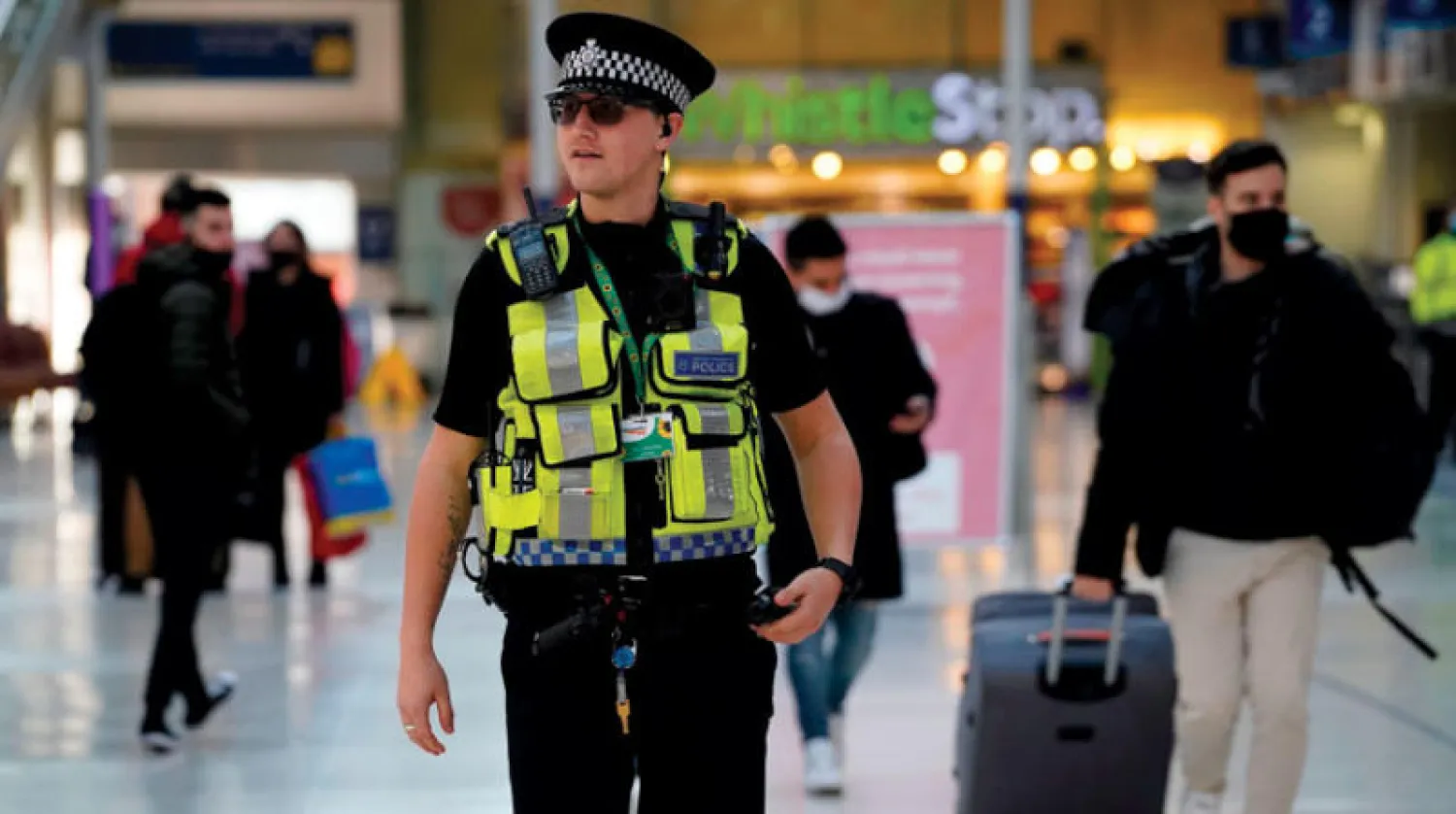 شرطي في محطة واترلو للقطارات في لندن أمس مع تشديد القيود بسبب فيروس «كورونا المتحور» (أ.ف.ب)