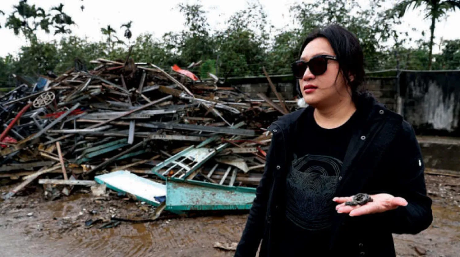 تبحث وانغ لي لينغ في النفايات عن مواد تستخدمها لتصميم الملابس (رويترز)