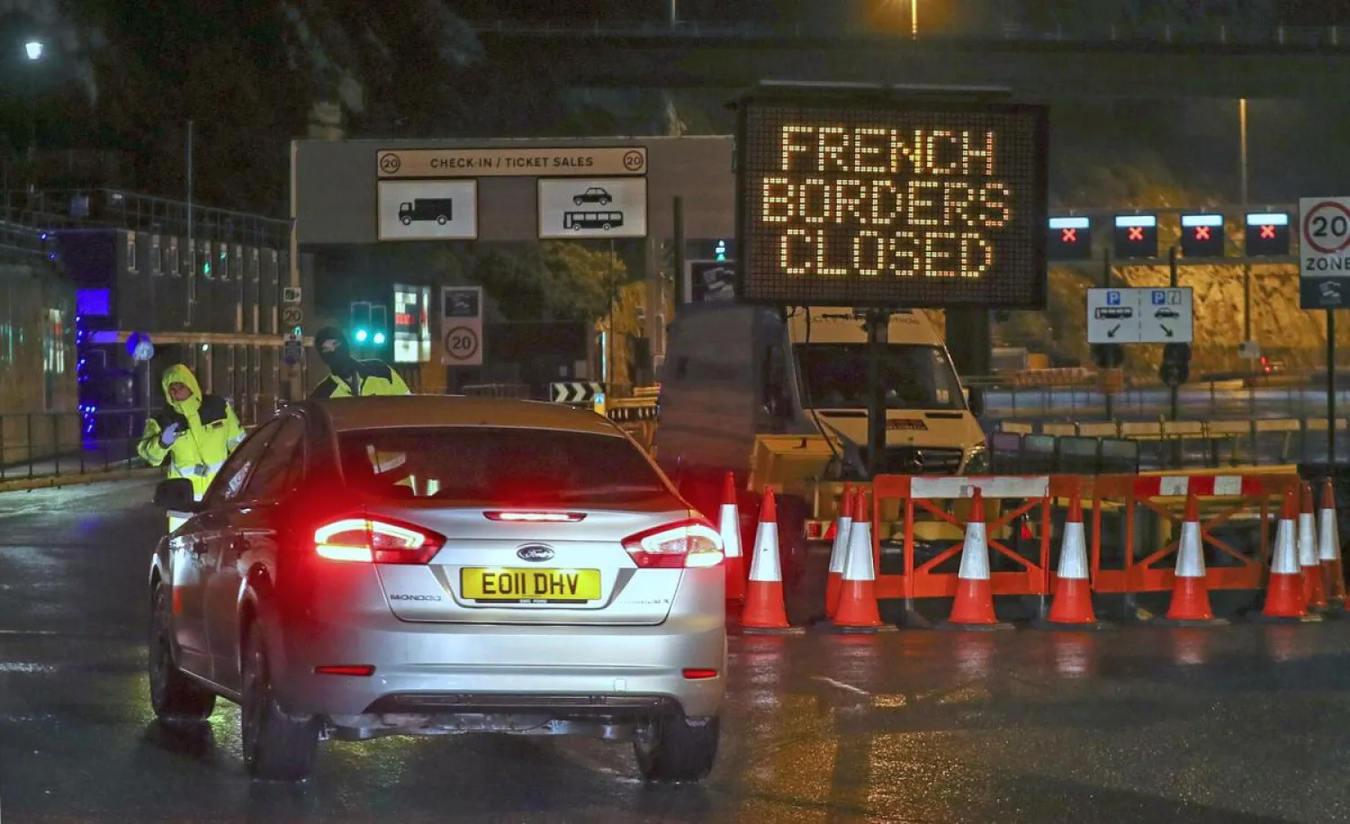 Police and port staff turn away a vehicle from the Port of Dover in Kent, England which has been closed after the French government's announcement, Monday, Dec. 21, 2020. (Steve Parsons/PA via AP)