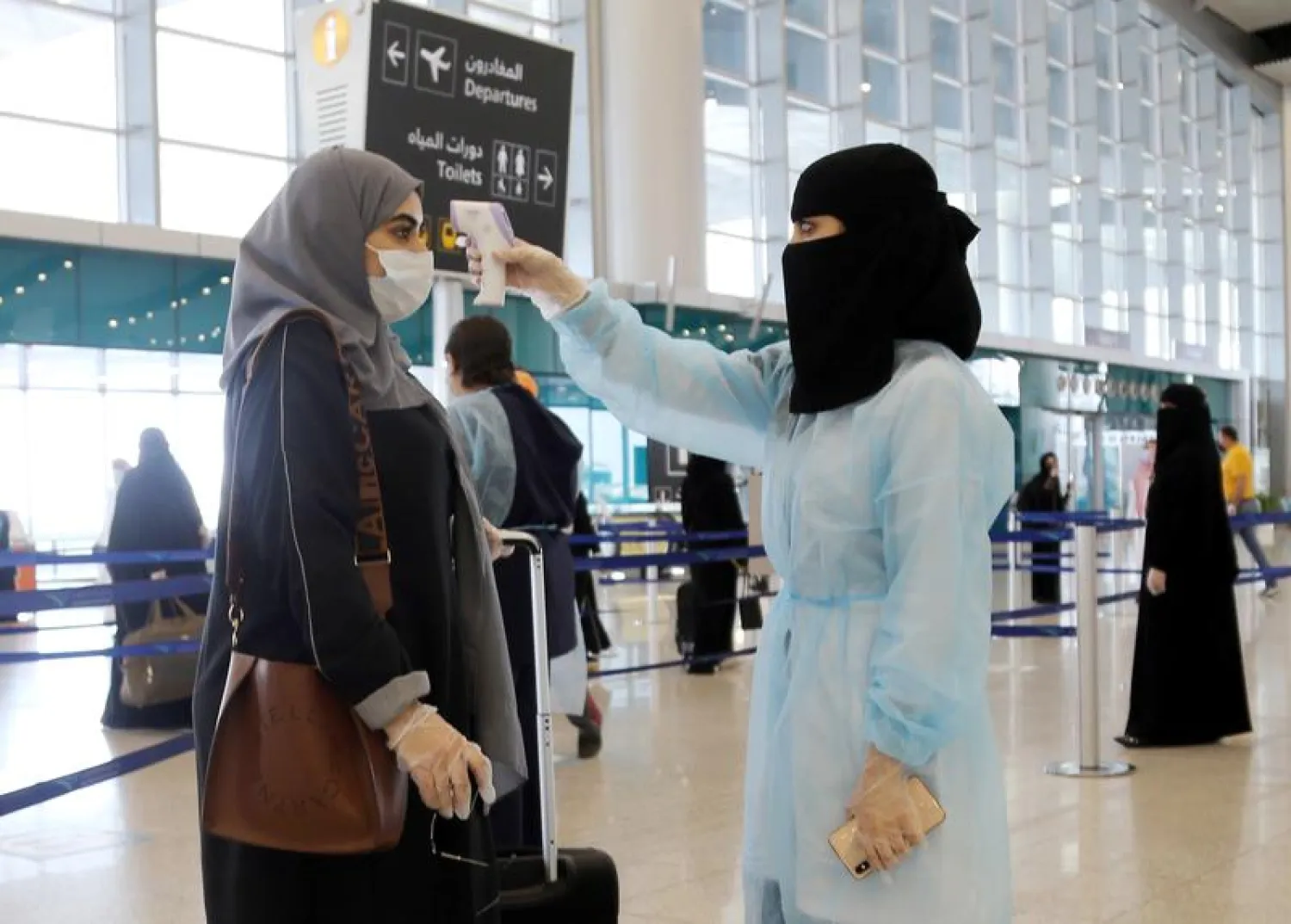 FILE PHOTO: A security woman checks the temperature of a woman at Riyadh International Airport. FILE: REUTERS/Ahmed Yosri
