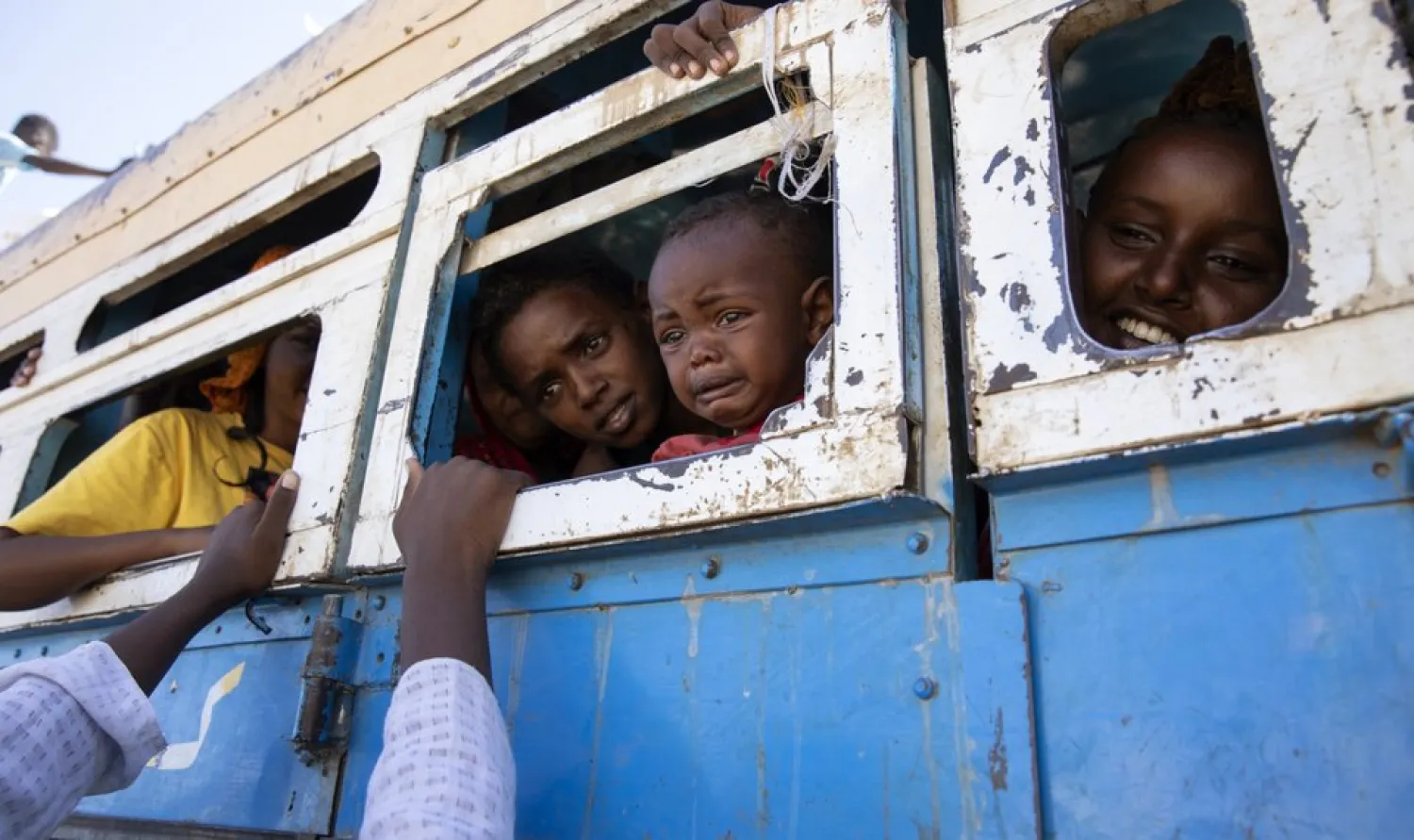 Refugees who fled the conflict in Ethiopia's Tigray region ride a bus going to the Village 8 temporary shelter, near the Sudan-Ethiopia border, in Hamdayet, eastern Sudan, Tuesday, Dec. 1, 2020. (AP Photo/Nariman El-Mofty)