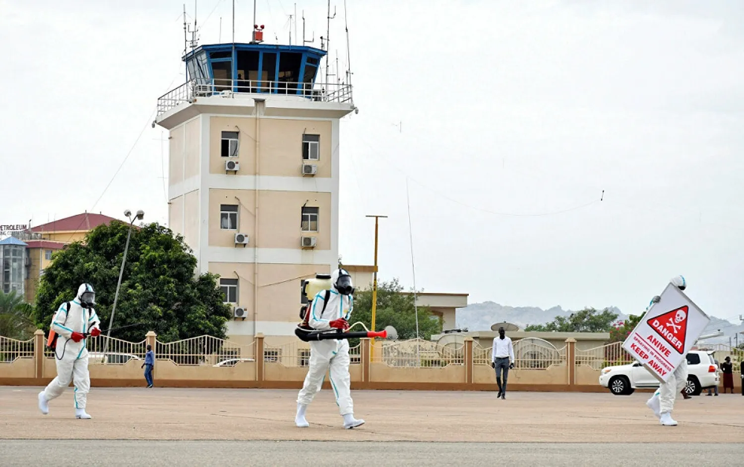 Members of a medical team wearing protective suits clean the airfield at the Juba International Airport. (Reuters)