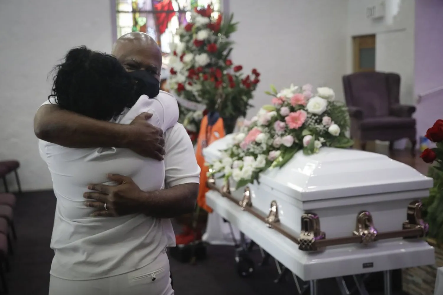 FILE - In this July 21, 2020, file photo, Darryl Hutchinson, facing camera, is hugged by a relative during a funeral service for Lydia Nunez, who was Hutchinson's cousin at the Metropolitan Baptist Church in Los Angeles. Nunez died from COVID-19. (AP Photo/Marcio Jose Sanchez, File)

