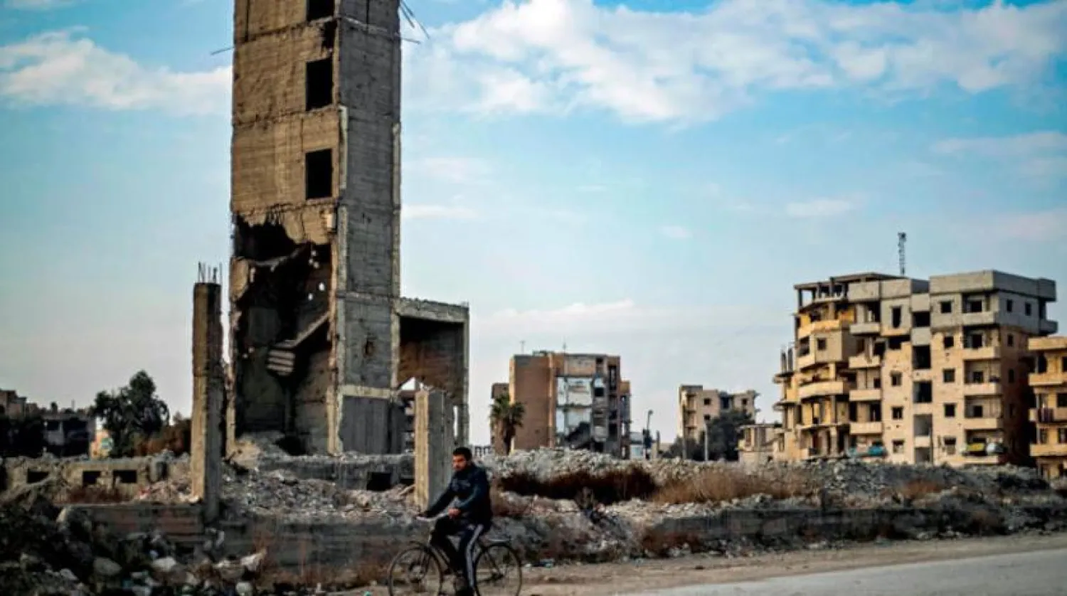 Dün Suriye'nin kuzeydoğusundaki Rakka'da bir sokakta yol alan bisikletli bir adam (AFP)