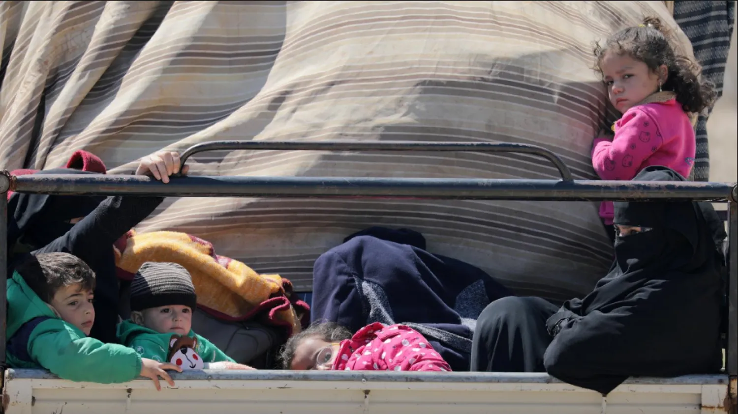 Displaces Syrian children ride on back of a truck as they move back home, as some people are afraid of the coronavirus disease (COVID-19) outbreak in crowded camps, in Dayr Ballut, Syria April 11, 2020. REUTERS/Khalil Ashawi