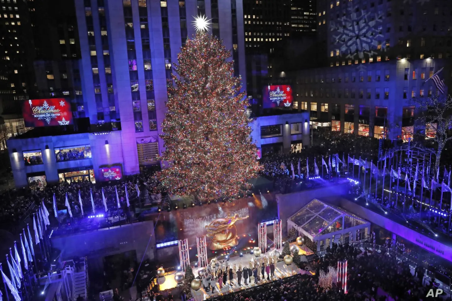 Dignitaries on stage push a button igniting the 50,000 multicolored LED lights during the 87th annual Rockefeller Center Christmas Tree lighting ceremony, Dec. 4, 2019, in New York. | AP