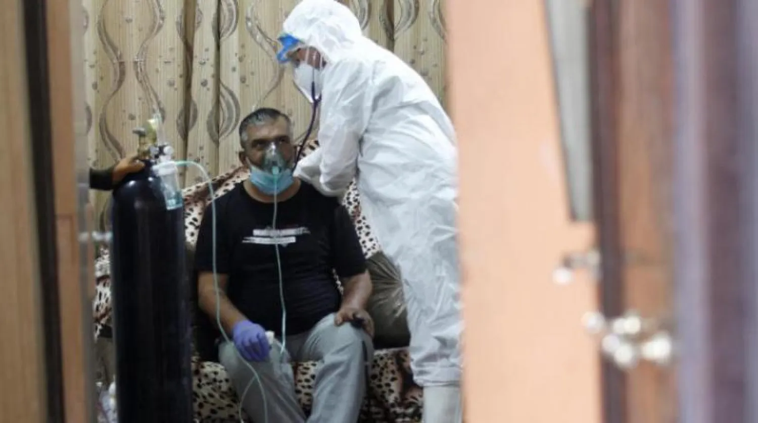 متطوع يعتني بمريض مصاب بفيروس «كورونا» في مدينة النجف العراقية (رويترز)