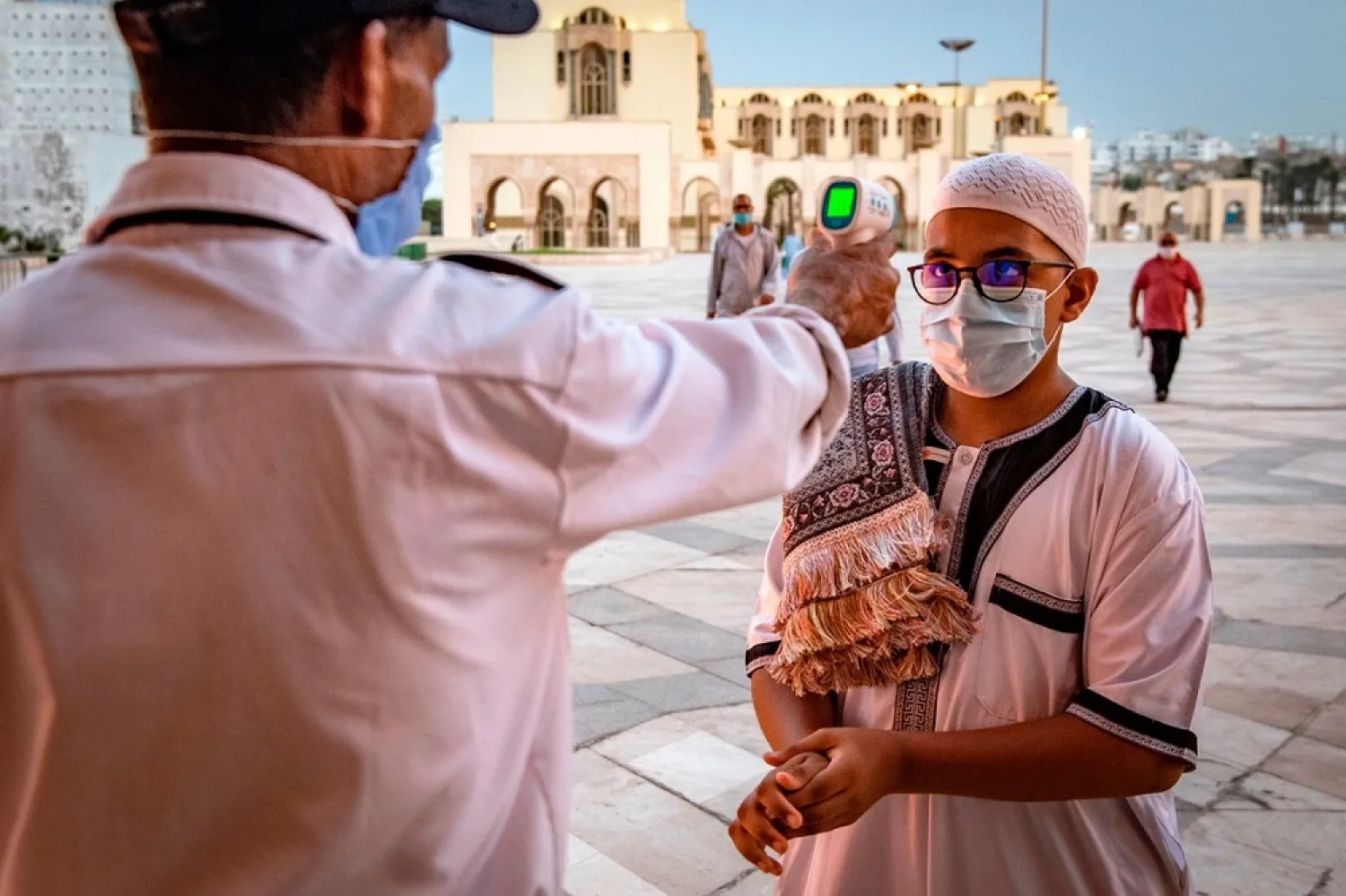 A mask-clad worker checks the body temperature of incoming worshippers in Morocco's Casablanca on June 16, 2020. (Getty Images)
