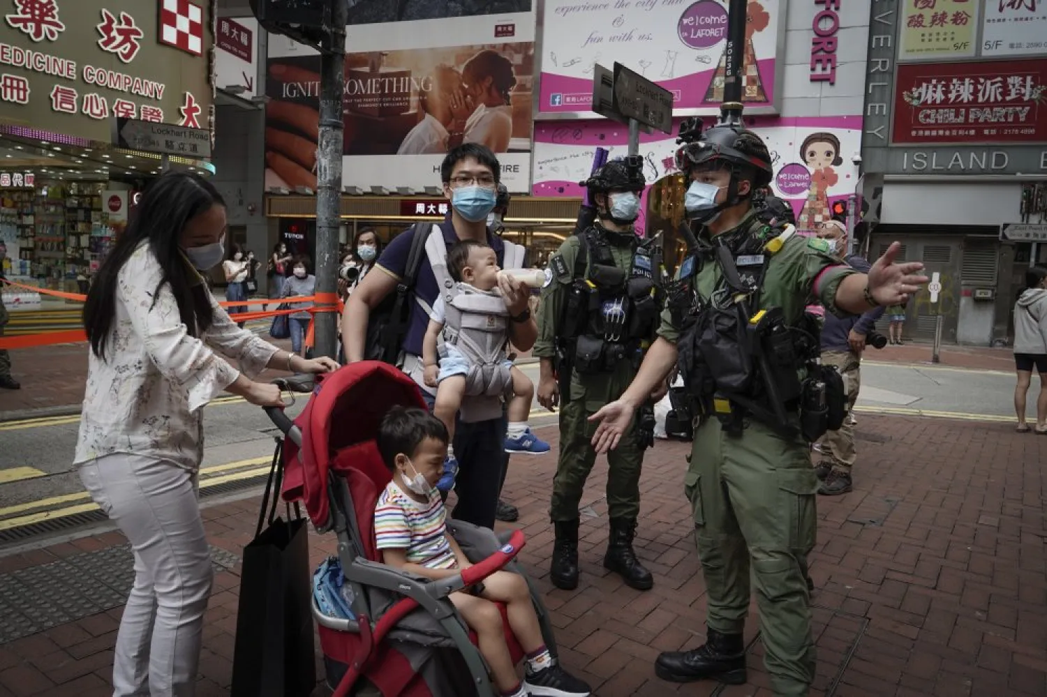 FILE:A family is diverted by police as a precaution during China's National Day in Causeway Bay, Hong Kong, on Thursday, Oct. 1, 2020. (AP Photo/Kin Cheung)
