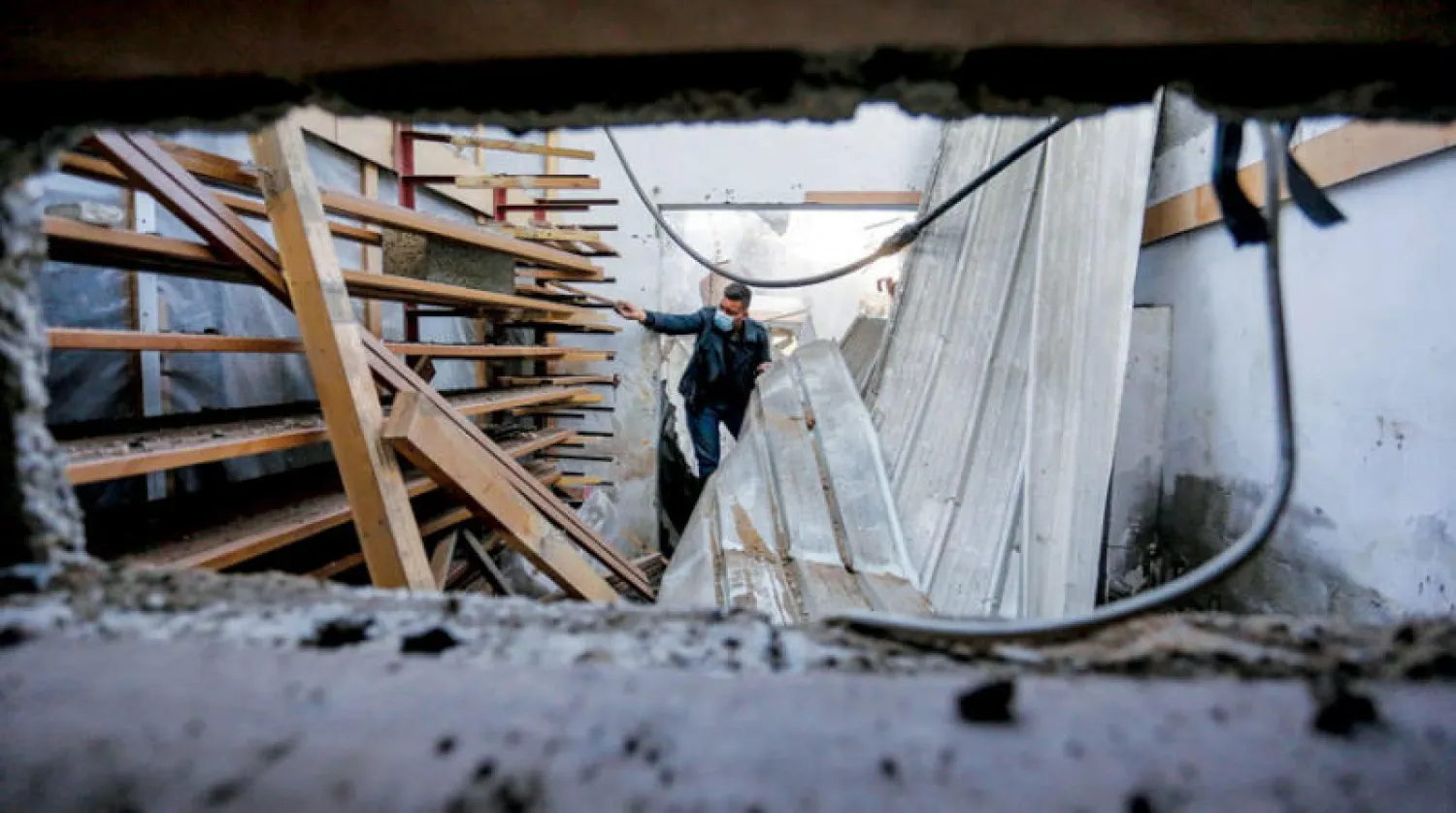 رجل يتفحص الدمار الذي لحق بورشته بعد قصف الطيران الإسرائيلي غزة السبت (د.ب.أ)