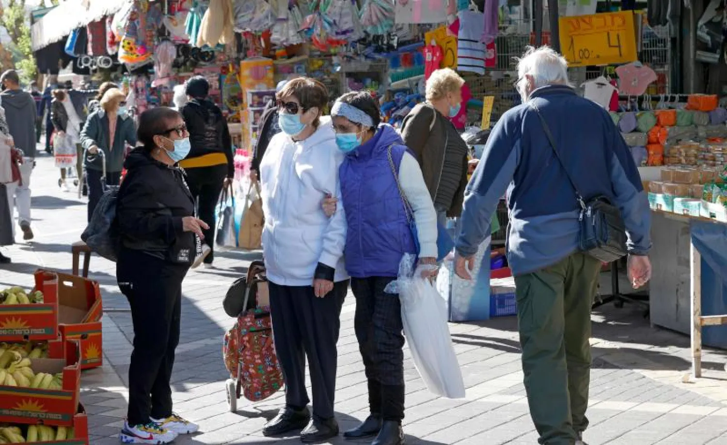 إسرائيليون يرتدون أقنعة واقية يتسوقون في السوق المركزية لمدينة نتانيا الساحلية في إسرائيل (أ.ف.ب)