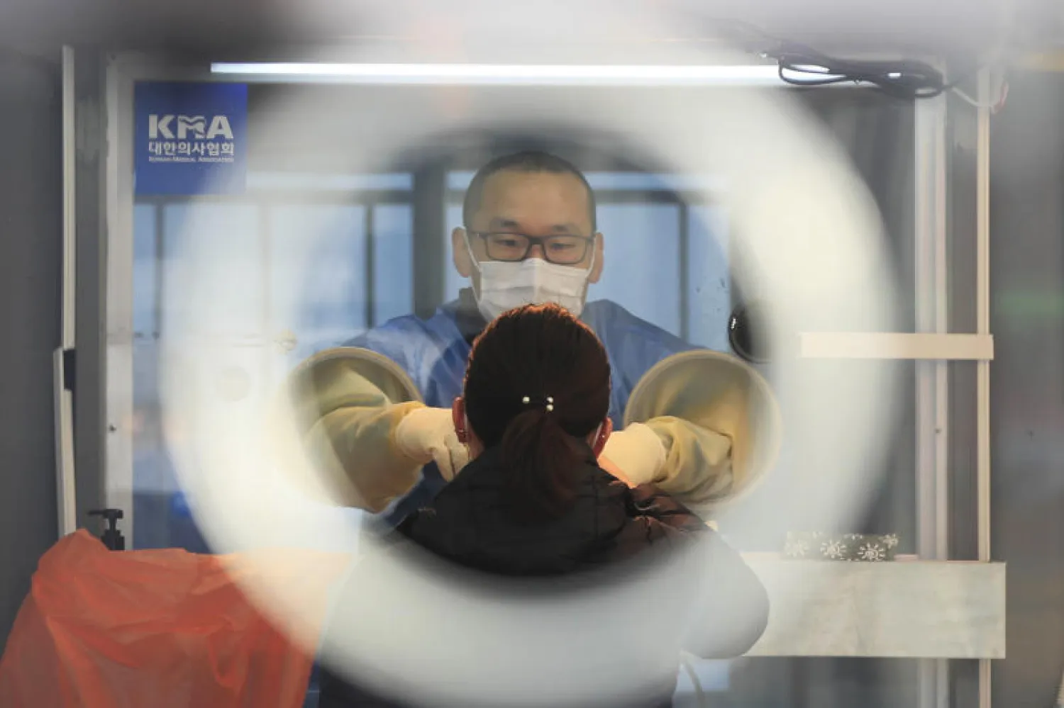 عامل بالرعاية الصحية يرتدي ملابس واقية يستعد لأخذ عينة بموقع لاختبارات كورونا في سيول (أ.ب)