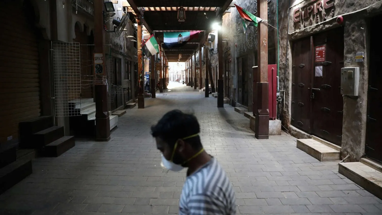 A man wearing a protective face mask walks through the deserted Barajeel Souq, following the outbreak of the coronavirus disease (COVID-19), in old Dubai, UAE, March 31, 2020. (Reuters)