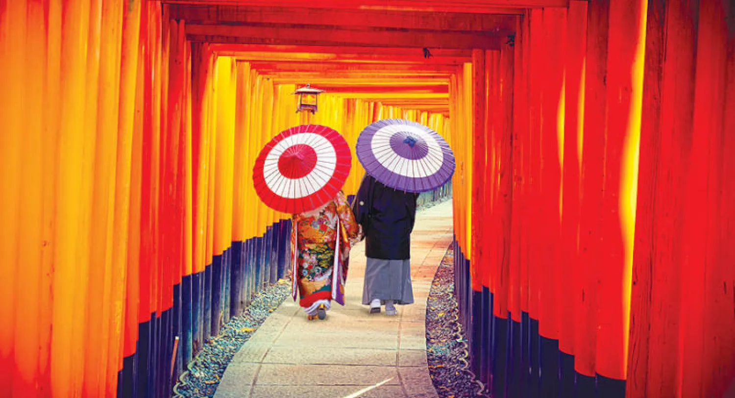 زائران يسيران في ضريح فوشيمي إيناري في كيوتو باليابان