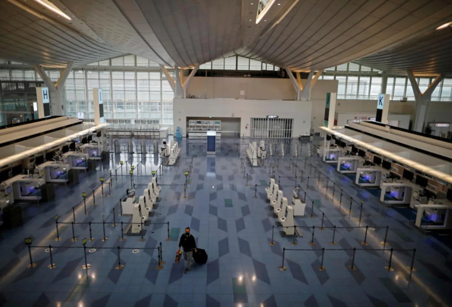راكب شوهد في منطقة إنهاء إجراءات السفر في صالة الرحلات الدولية بمطار هانيدا في طوكيو (رويترز)