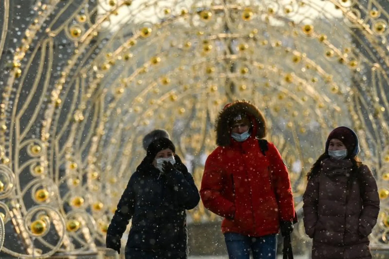 أشخاص يرتدون أقنعة واقية للوجه وهم يسيرون في شوارع موسكو (أ.ف.ب)