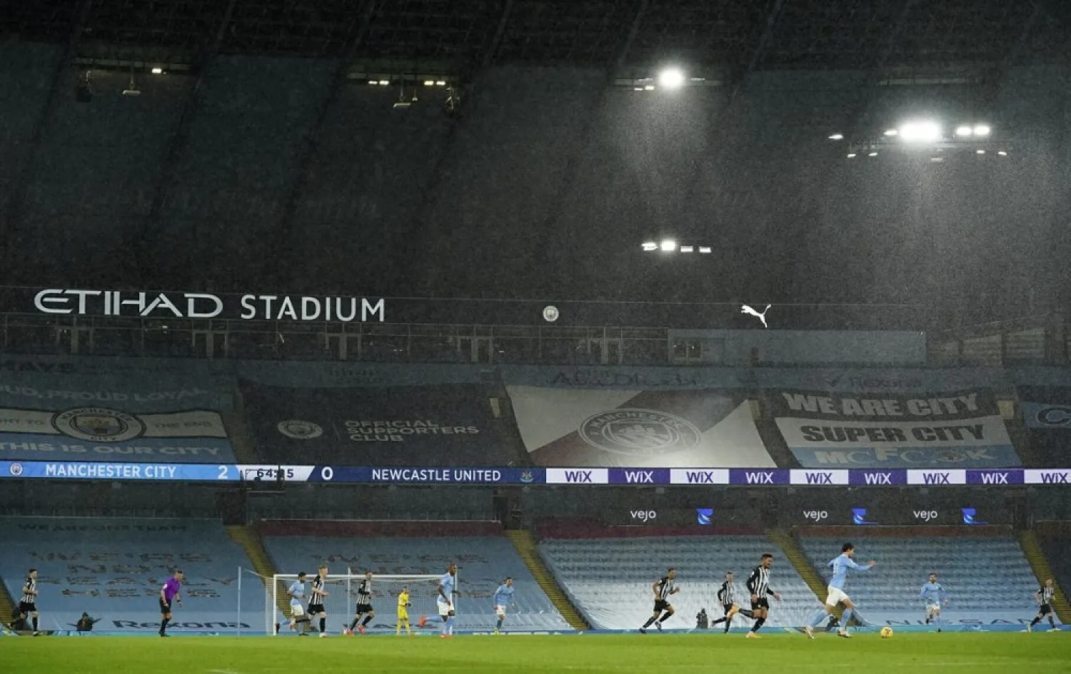 Players in the torrential rain during the English Premier League match between Manchester City and Newcastle United at the Etihad stadium in Manchester, Dec. 26, 2020. (AP)