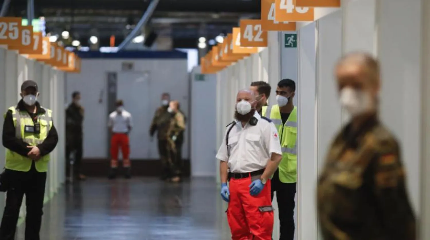 Kızıl Haç çalışanları, silahlı kuvvetler mensupları ve yardım görevlileri Berlin’deki bir aşı merkezinde Pfizer-BioNTech aşısını olmayı bekliyor (DPA)