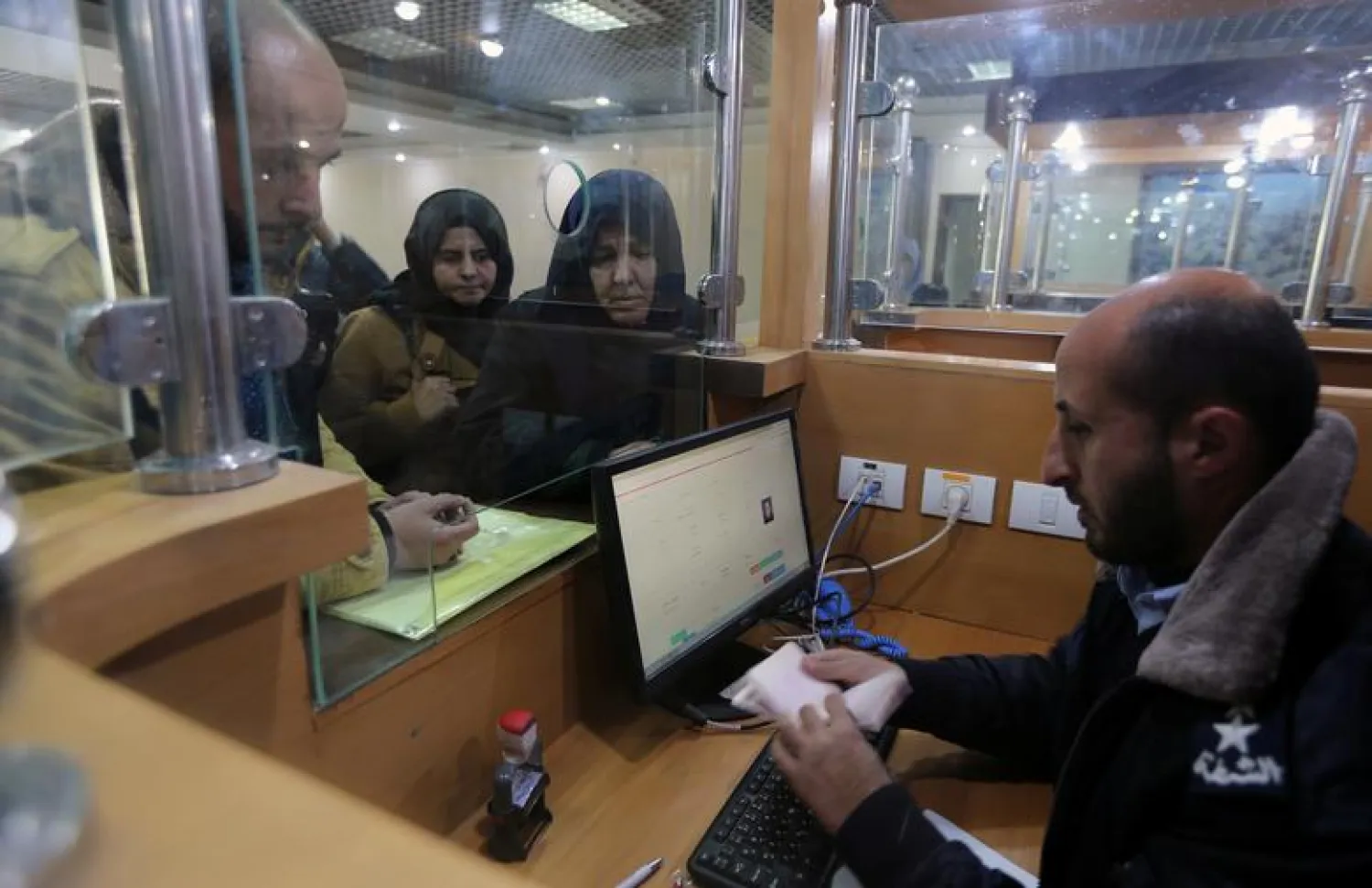 A Palestinian Hamas-hired police officer checks the documents of people upon their return from Egypt, at the Rafah border crossing in the southern Gaza Strip on January 8, 2019. REUTERS/Ibraheem Abu Mustafa