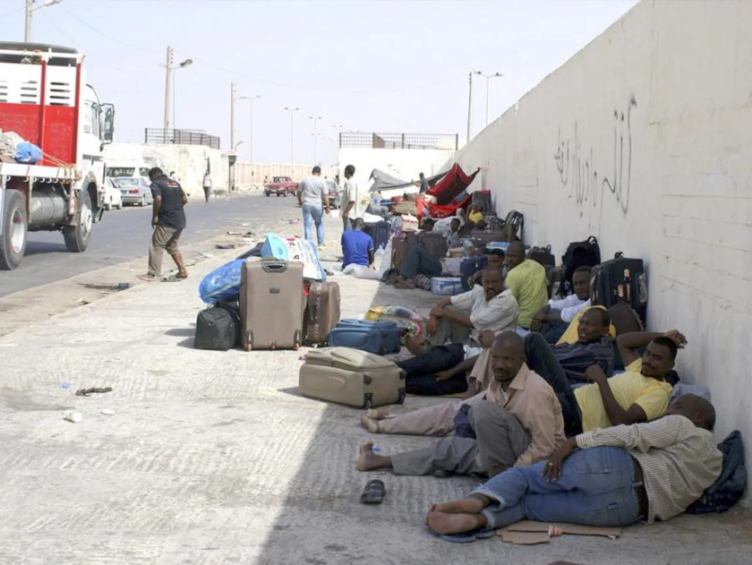 Sudanese workers rest as they wait for Egyptian visas next to the Libyan-Egyptian border crossing in Musaid. Reuters file photo