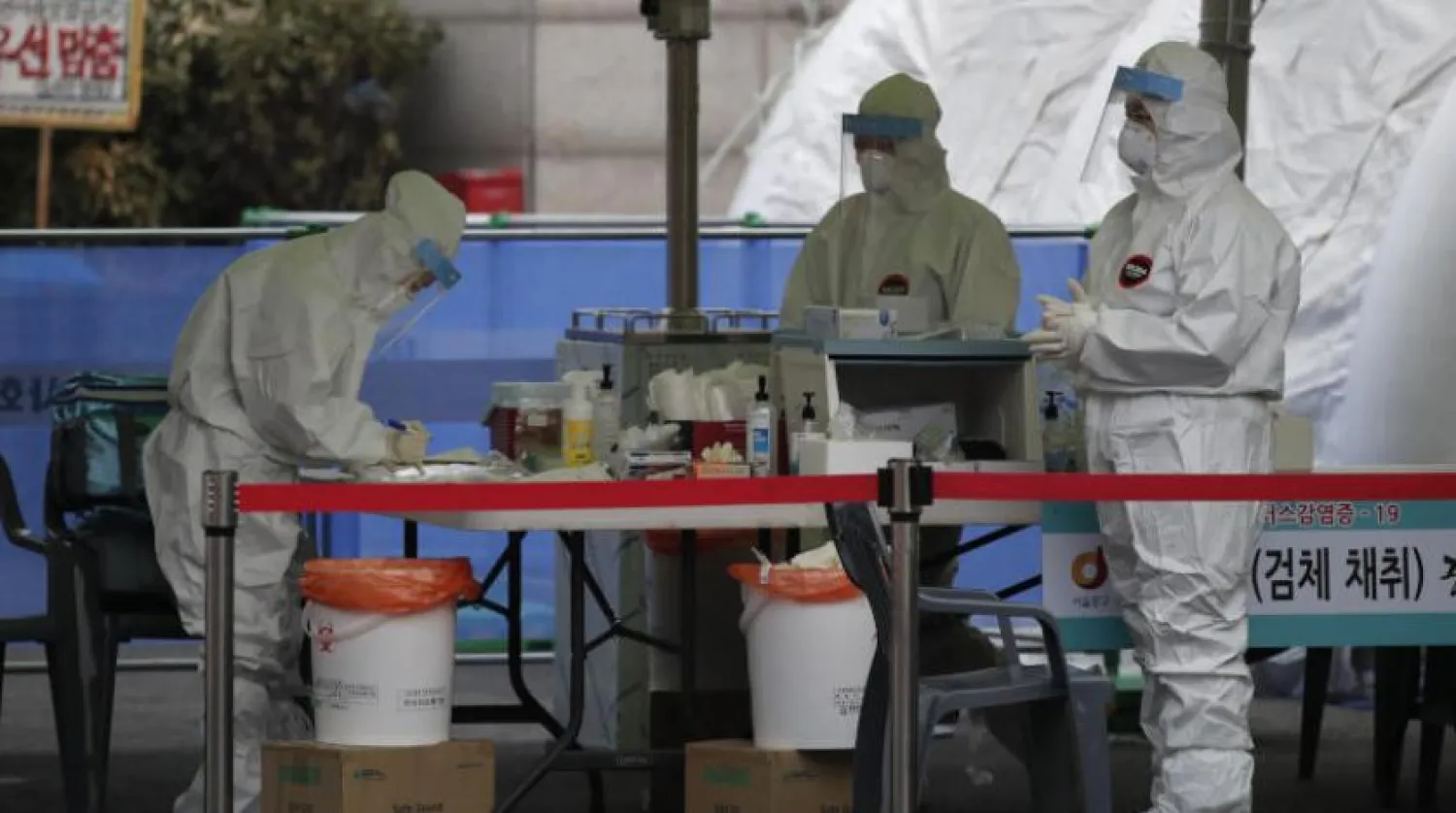 Koruyucu giysili sağlık çalışanları, Seul'deki bir korona test merkezinde (AP)
