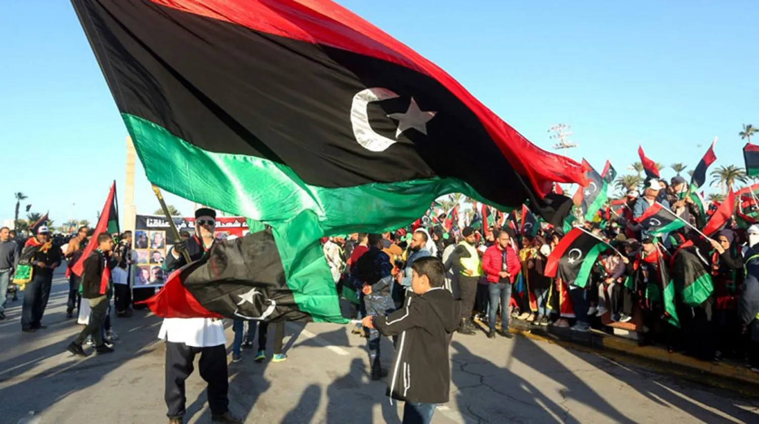 Libyalılar, eski Devlet Başkanı Muammer Kaddafi'ye karşı gerçekleştirilen ayaklanmanın dokuzuncu yıl dönümünde ulusal bayrağı dalgalandırıyor. (AFP)