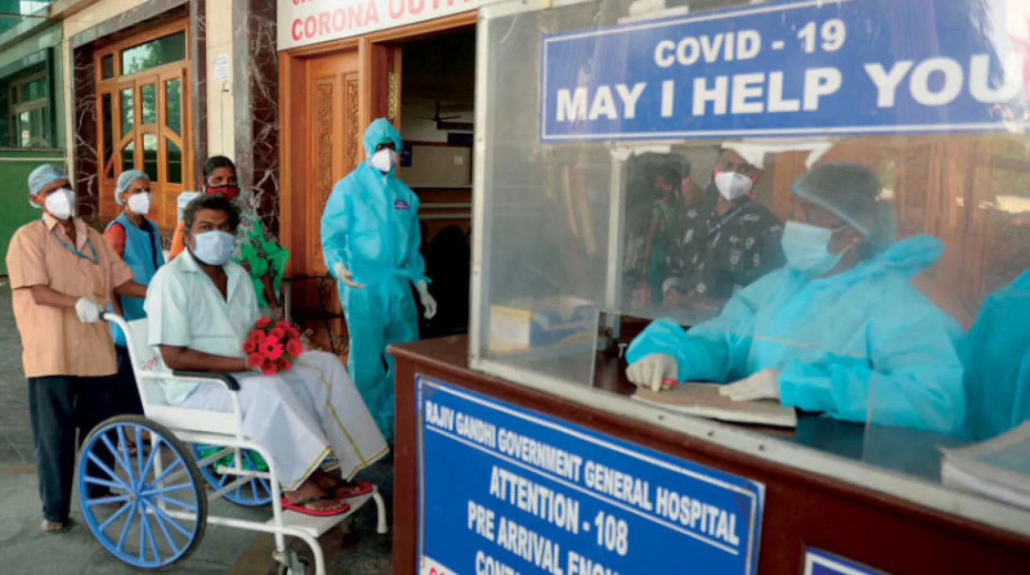 مريض يغادر المستشفى بعد تعافيه من كورونا في الهند (أ.ف.ب)