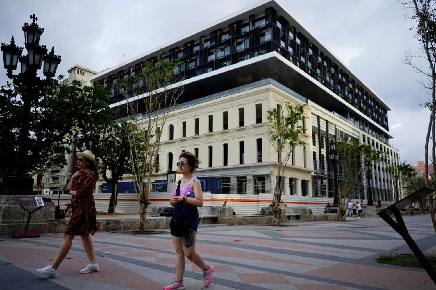 Tourists pass by a hotel under construction at the Paseo del Prado boulevard in Havana, Cuba, May 9, 2018. Picture taken on May 9, 2018. REUTERS/Alexandre Meneghini