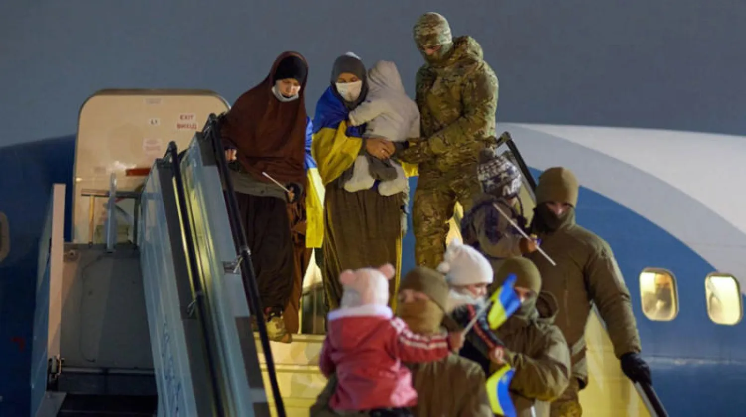 صورة وزعتها الرئاسة الأوكرانية أمس لنساء وأطفال كانوا في مخيم لإيواء عائلات يشتبه في ارتباطها بـ«داعش» في سوريا وتولت قوات أوكرانية نقل امرأتين و8 أطفال بطائرة وصلت من سوريا إلى مطار قرب العاصمة كييف في أول أيام السنة الجديدة (أ.ب)