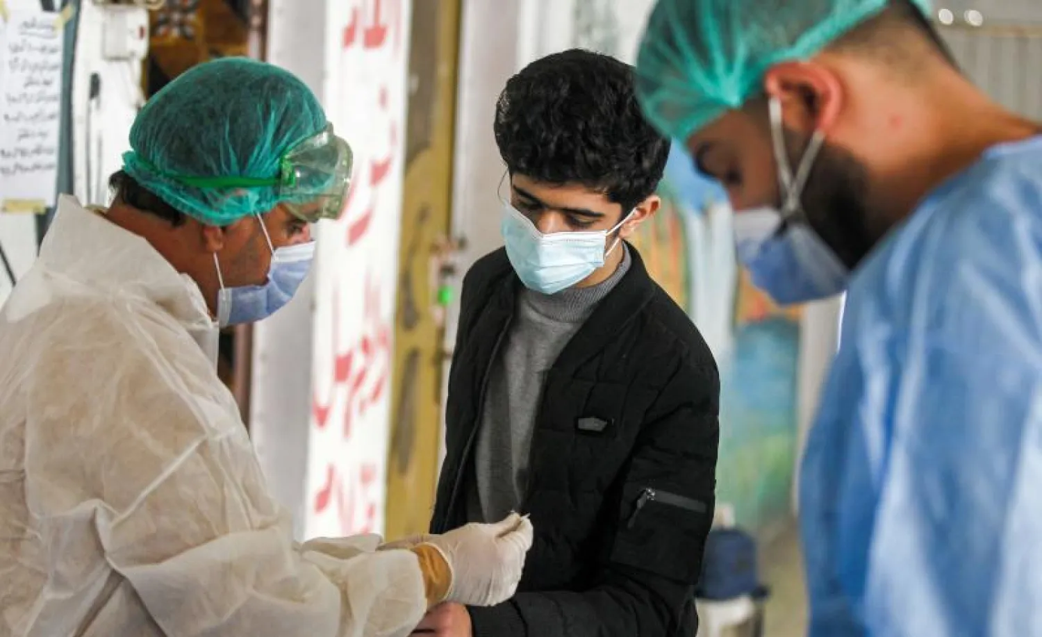 طالب يخضع لاختبار دم للكشف عن فيروس كورونا في العراق (أ.ف.ب)