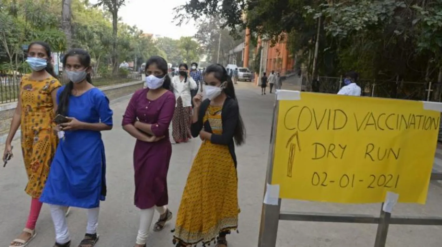 Hintli kadınlar Haydarabad'da  bir sokakta maske takıyor (AFP)
