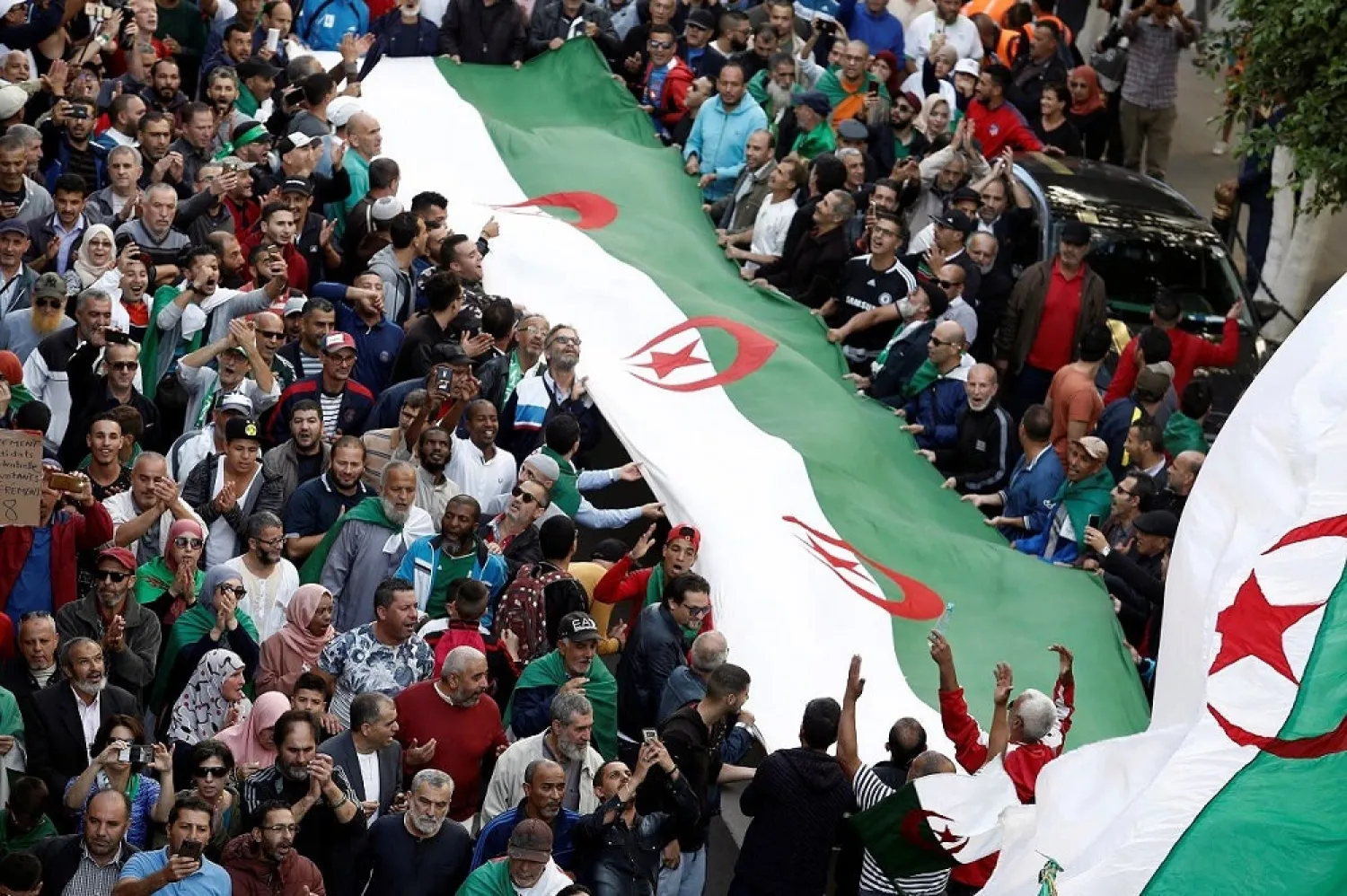 Demonstrators carry national flags during a protest against the country's ruling elite and rejecting December presidential election in Algiers, Algeria, October 25, 2019. (Reuters)