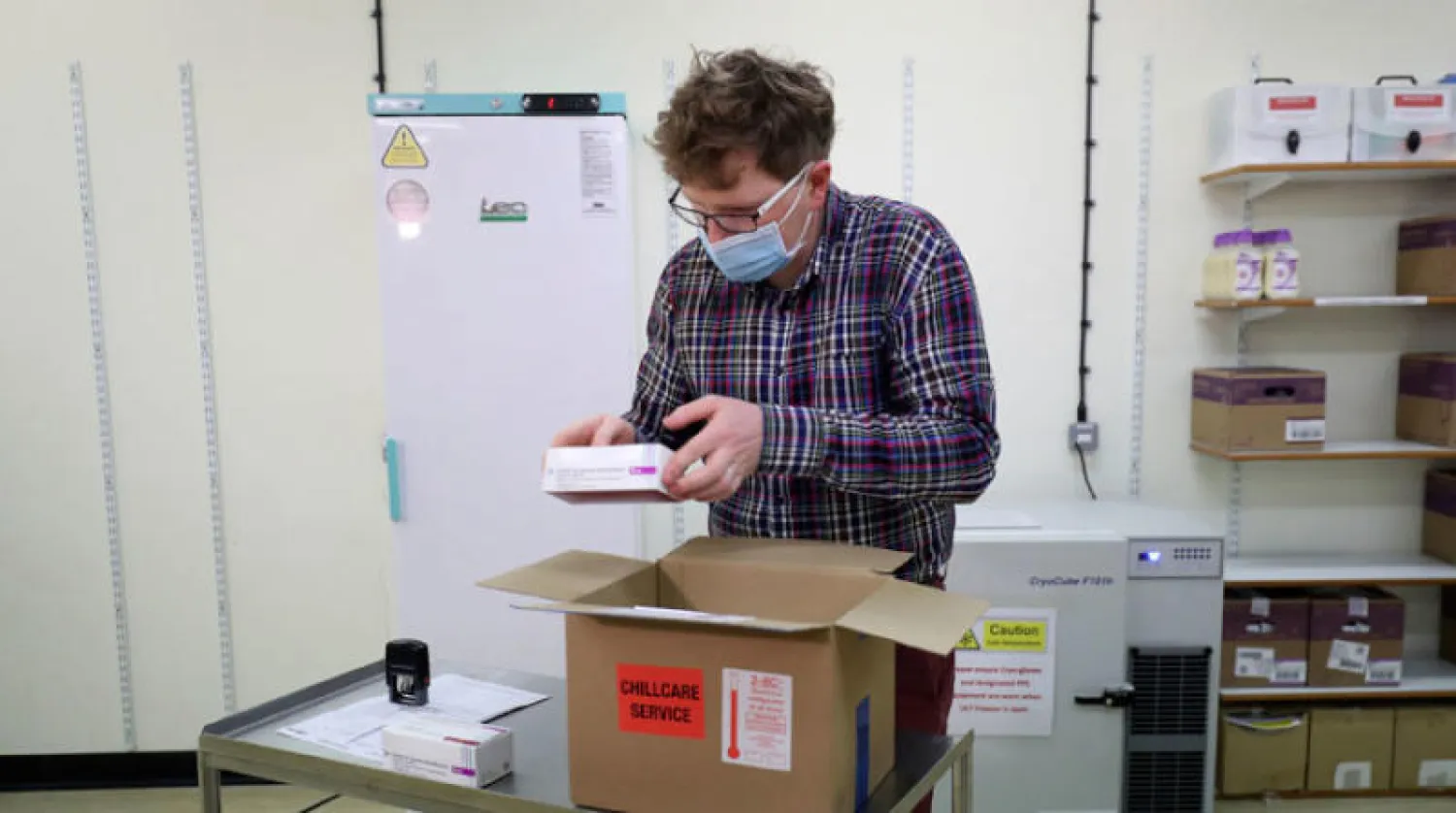 عامل صحة يراجع شحنة من لقاح «أكسفورد - أسترازينيكا» في لندن أمس (أ.ب)