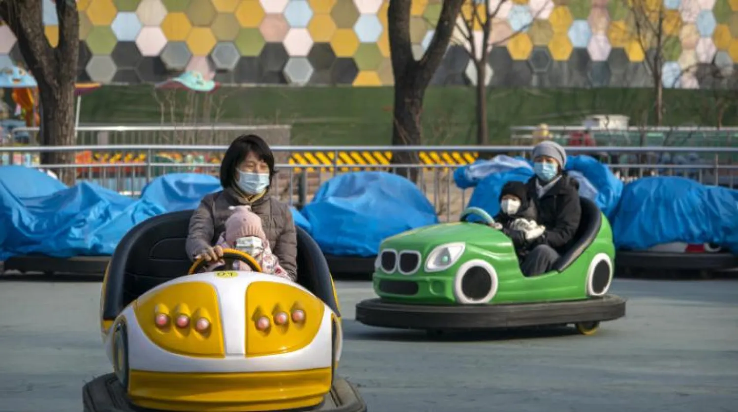 Çinliler yeni yılı bir lunaparkta maske takarak kutluyor (AP)
