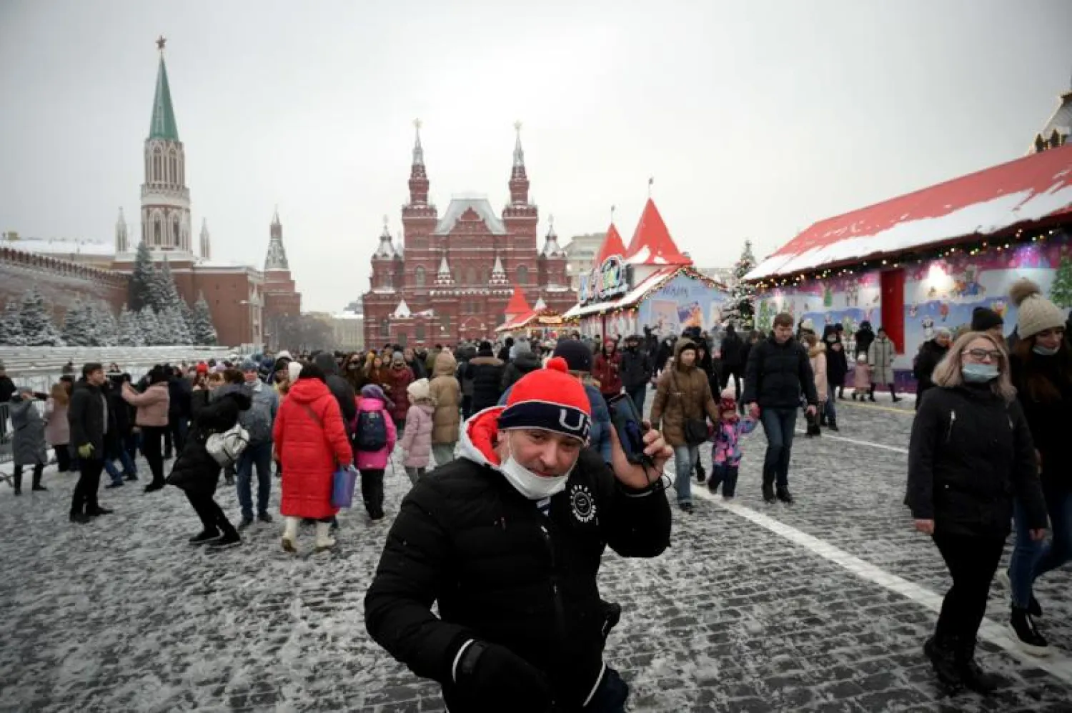 رجل يرتدي قناعاً واقياً للوجه يسير في الميدان الأحمر وسط موسكو (أ.ف.ب)