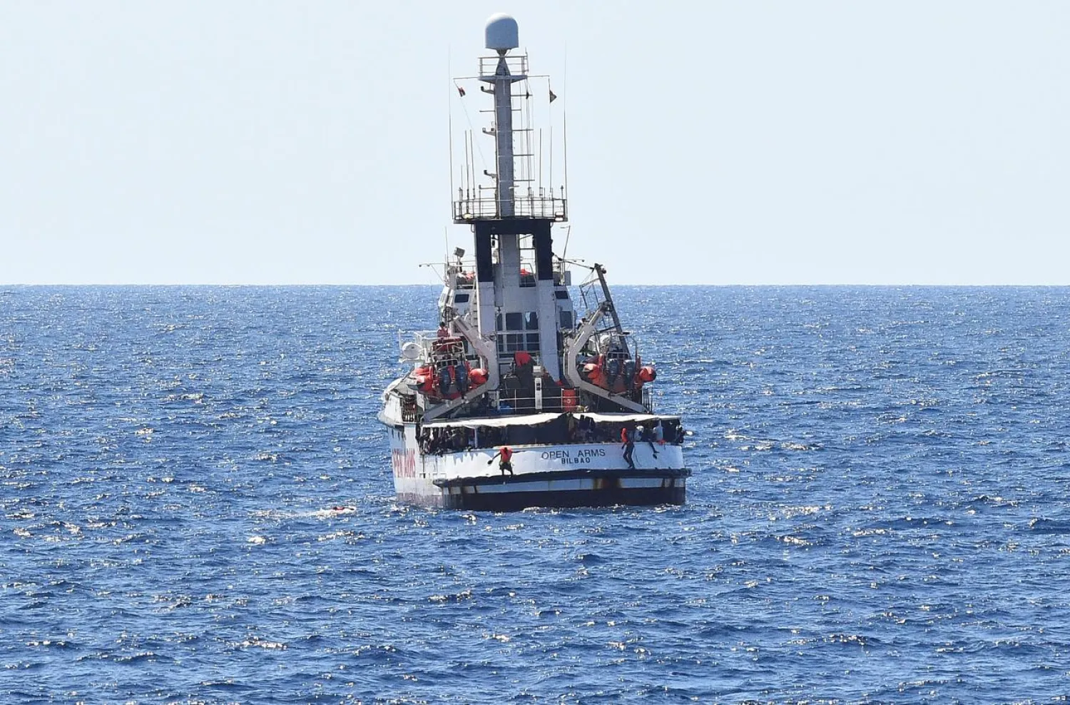 Migrants jump off the Spanish rescue ship Open Arms, close to the Italian shore in Lampedusa, Italy August 20, 2019. REUTERS/Guglielmo Mangiapane