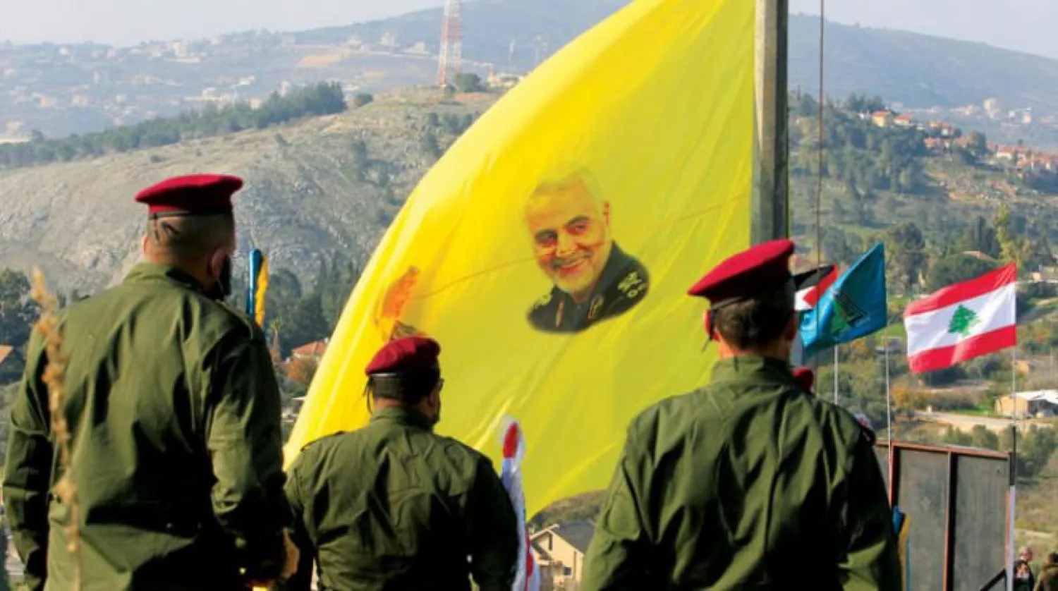 Geçen cumartesi günü Lübnan- İsrail sınırında Kasım Süleymani’nin fotoğrafının olduğu bir bayrağın önündeki Hizbullah mensupları (Reuters)