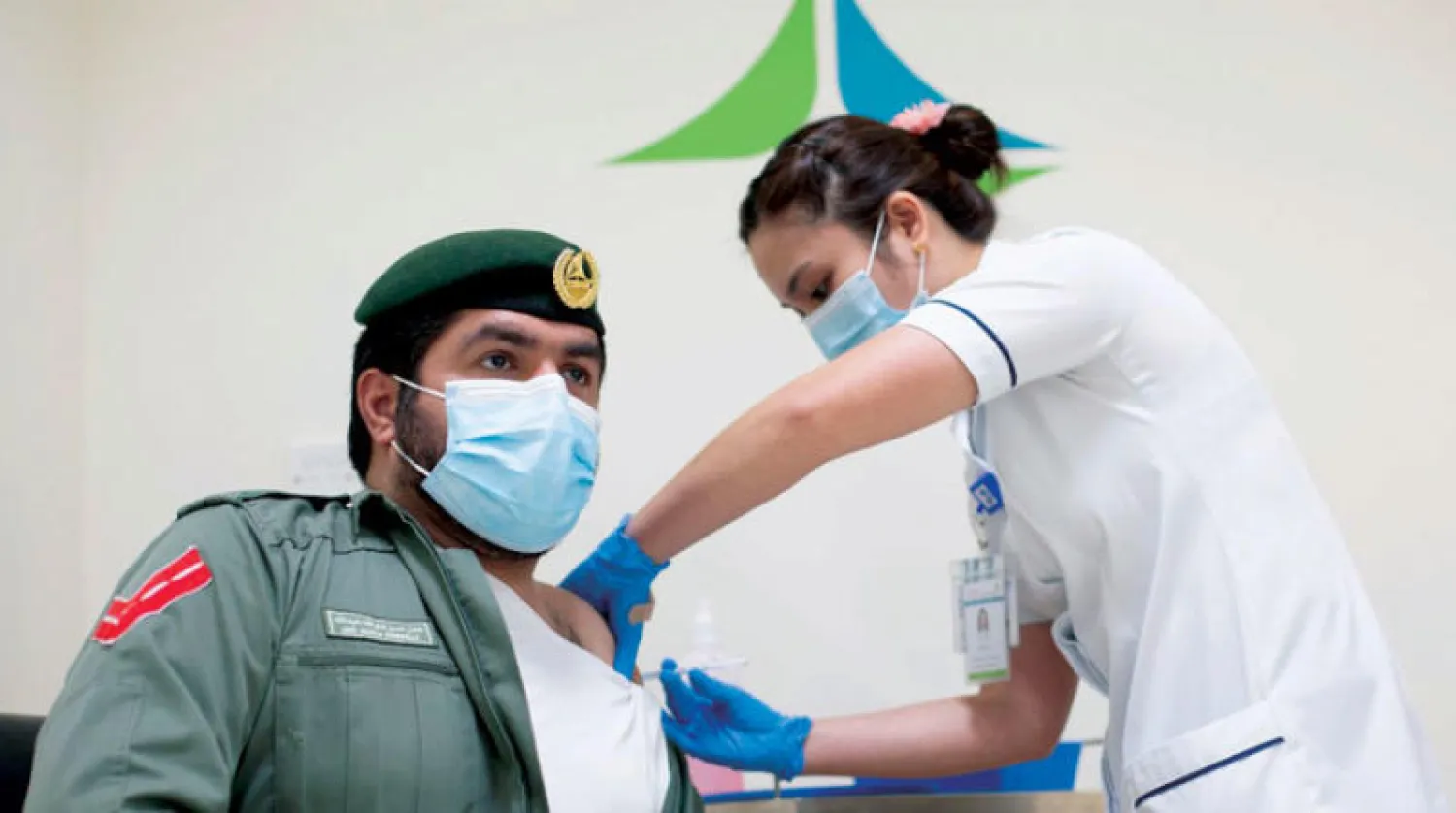 شرطي إماراتي يتلقى اللقاح في دبي (وام)