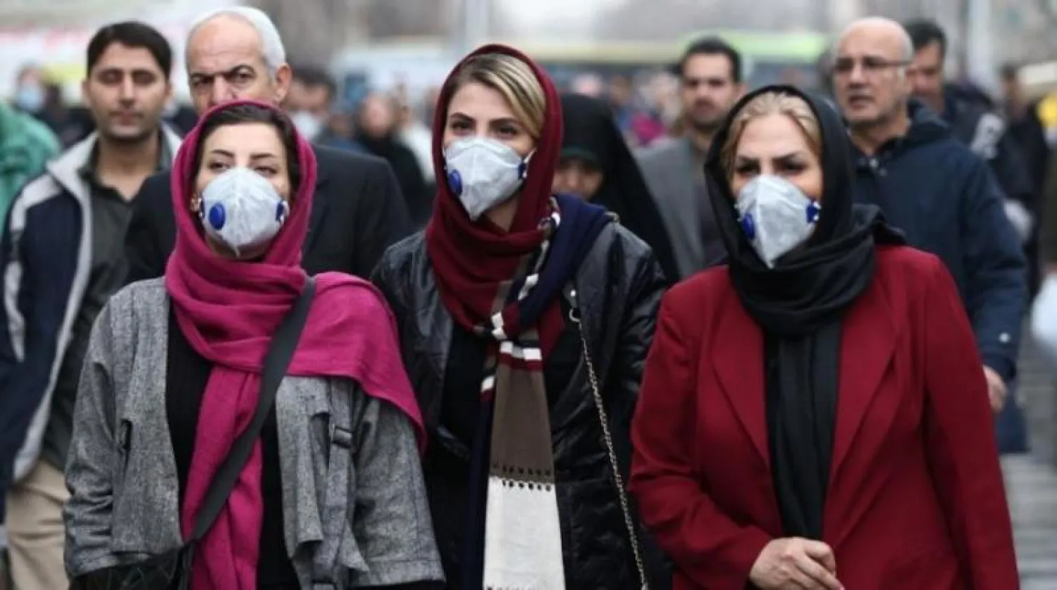 إيرانيات يضعن كمامات في أحد شوارع طهران (رويترز)