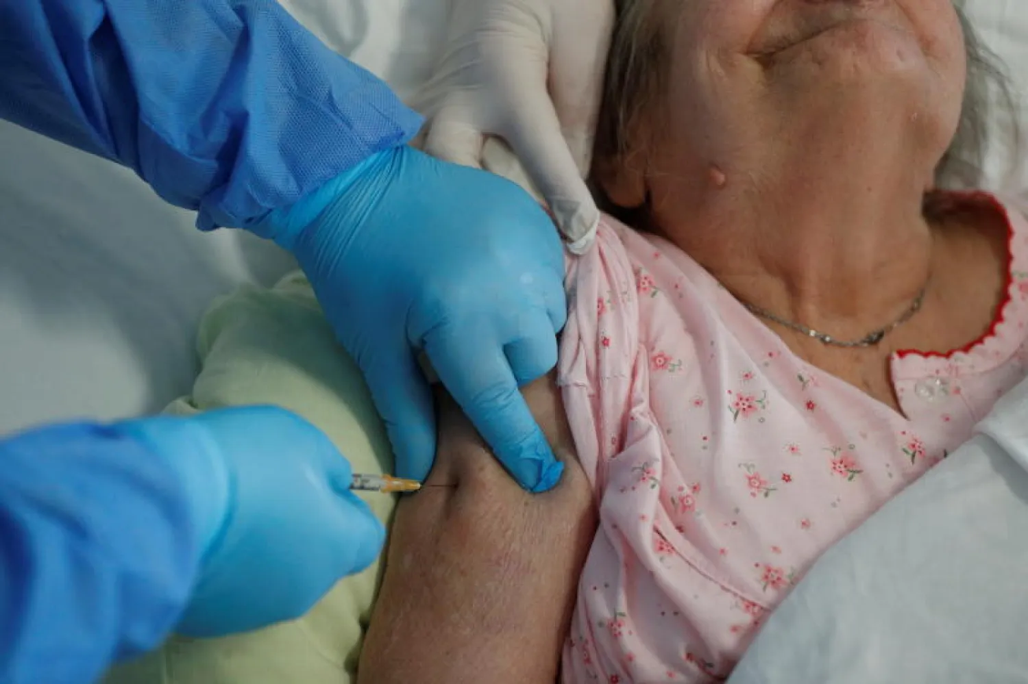 مسنّة تتلقى جرعة من لقاح «فايزر» المضاد لـ«كورونا» (رويترز)