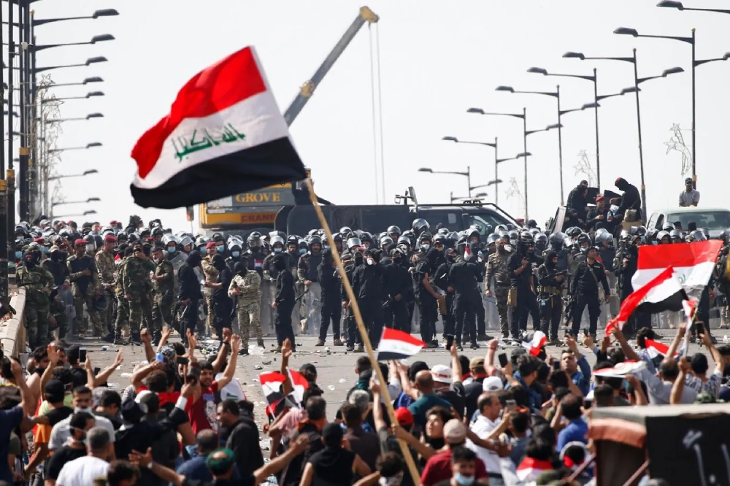 Iraqi security forces stand in front of demonstrators during a protest over corruption, lack of jobs and poor services, in Baghdad, Iraq in October 2019. (Reuters)