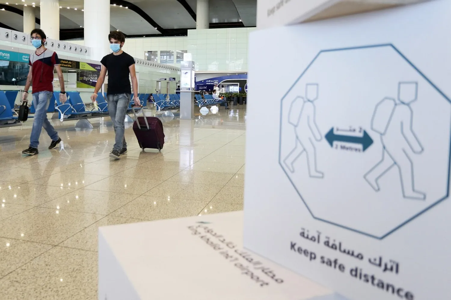 Travelers wearing protective face masks walk at Riyadh International Airport, in Riyadh, Saudi Arabia May 31, 2020. (Reuters)